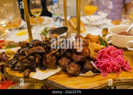Assiette de viande frite sur charbon de bois avec épices sur un panneau de bois. Carré d'agneau, de porc, de kebab, de poulet, de champignons et de sauces tomate pour la viande Banque D'Images