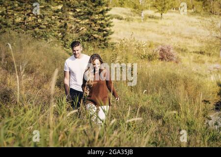 Mari et femme passent du temps ensemble de qualité à l'extérieur près d'un ruisseau dans un parc de la ville; Edmonton, Alberta, Canada Banque D'Images