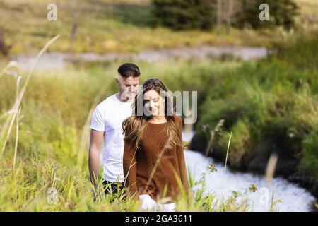 Mari et femme passent du temps ensemble de qualité à l'extérieur près d'un ruisseau dans un parc de la ville; Edmonton, Alberta, Canada Banque D'Images