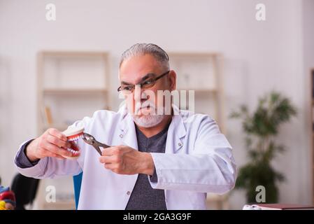 Ancien professeur de dentiste assis dans la salle de classe Banque D'Images