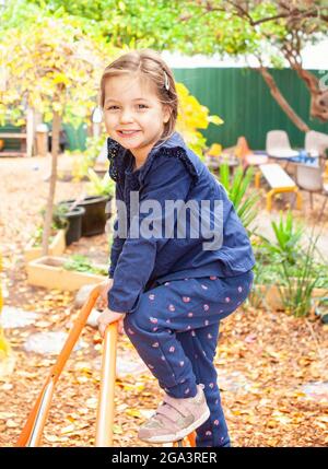 Un enfant heureux sur l'équipement d'escalade en automne Banque D'Images