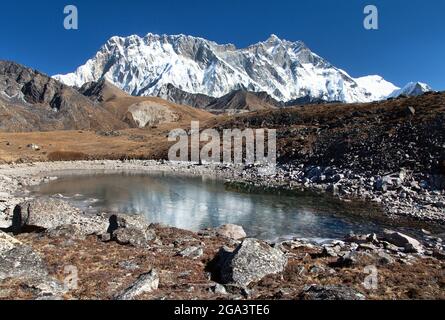 Vue panoramique de Lhotse et Nuptse face sud de roche miroir dans le petit lac, la région de l'Everest, le parc national de Sagarmatha, vallée de Khumbu, Solukhumbu, Népal Banque D'Images