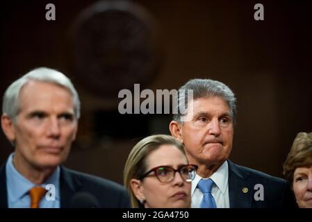 Le sénateur américain Kyrsten Sinema (démocrate de l’Arizona), deuxième de gauche, le sénateur américain Joe Manchin III (démocrate de la Virginie occidentale), deuxième de droite, et le sénateur américain Jeanne Shaheen (démocrate du New Hampshire), à droite, écoutent le sénateur américain Rob Portman (républicain de l’Ohio), à gauche, Fait des remarques après le vote sur la motion d'invoquer le cloture pour procéder à l'étude de H.R. 3684, la loi INVEST in America sur Capitol Hill à Washington, DC, le mercredi 28 juillet 2021. Le vote pour entamer la discussion sur le projet de loi bipartisan sur les infrastructures, approuvé par le White H. Banque D'Images