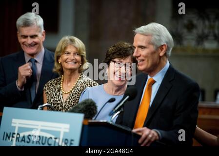 Le sénateur des États-Unis Bill Cassidy (républicain de la Louisiane), à gauche, le sénateur des États-Unis Lisa Murkowski (républicaine de l'Alaska), deuxième de gauche, et le sénateur des États-Unis Susan Collins (républicaine du Maine), deuxième de droite, se font rire tandis que le sénateur des États-Unis Rob Portman (républicain de l'Ohio), à droite, Fait des remarques après le vote sur la motion d'invoquer le cloture pour procéder à l'étude de H.R. 3684, la loi INVEST in America sur Capitol Hill à Washington, DC, le mercredi 28 juillet 2021. Le vote pour entamer la discussion sur le projet de loi bipartisan sur les infrastructures, approuvé par les blancs Banque D'Images