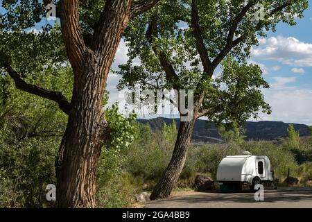 Campeur en forme de larme construit sur mesure garé sous des arbres de cotonnier au Green River Campground dans Dinosaur National Monument près de Jensen, Utah. Concept camping Banque D'Images