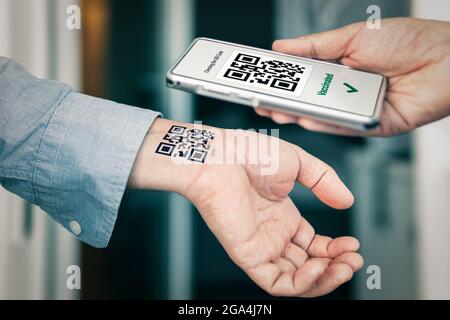 L'homme montre sa main avec un code qr, une confirmation de la vaccination contre le coronavirus Covid 19. Tatouage temporaire. Scannez le code QR à l'aide de TH Banque D'Images