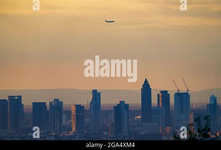 Kronberg, Allemagne. 29 juillet 2021. Un avion est seul dans le ciel au-dessus des gratte-ciels de la ville au lever du soleil à son approche de l'aéroport de Francfort, en regardant sur Francfort-sur-le-main depuis le bord des montagnes Taunus. Credit: Frank Rumpenhorst/dpa/Alay Live News Banque D'Images