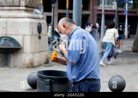 Homme traversant les poubelles, Barcelone, Espagne. Banque D'Images