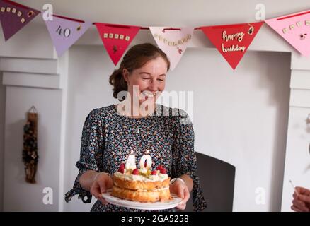 Une femme célèbre son 40e anniversaire en soufflant les bougies sur son gâteau d'anniversaire à Armoy, dans le comté d'Antrim, en Irlande du Nord. Banque D'Images