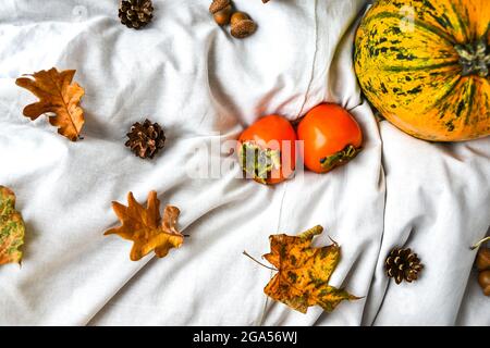 Citrouille sur fond blanc. Récolte d'automne. Copier l'espace. Persimmons et feuilles. Arrière-plan de l'automne Banque D'Images