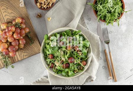 Salade délicieuse à base de raisins grillés caramélisés, d'arugula poivrée, de noix grillées et de pecorino. Banque D'Images