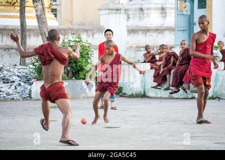 Groupe de jeunes moines birmans portant des robes de marron jouant au football au temple, Kalaw, Myanmar Banque D'Images