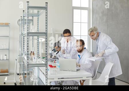 Une équipe de scientifiques communique et discute des résultats de l'étude en laboratoire. Banque D'Images