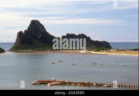 Thaïlande: Bateaux de pêche tôt le matin sur Ao Prachuap (baie de Prachuap), Prachuap Khiri Khan. En termes historiques, Prachuap est l'un des sept points d'atterrissage où les troupes impériales japonaises ont pris d'assaut à terre en 1941, sur leur chemin vers le sud pour occuper Malaya et Singapour. La ville est entourée par des montagnes de calcaire accidentées, dont Khao Chong Krajok, ou « montagne du tunnel miroir », est percée d’une ouverture naturelle qui ne ressemble pas à un miroir géant, et qui est peut-être le plus célèbre monument naturel de la ville. Banque D'Images