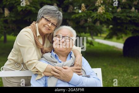 Portrait d'un couple senior heureux souriant et regardant l'appareil photo dans un parc d'été vert Banque D'Images