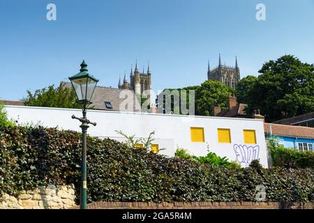 Lincoln Cathedral Twin West tours et Central tour de St Martins Street au-dessus du mur blanc de la propriété privée moderniste Banque D'Images