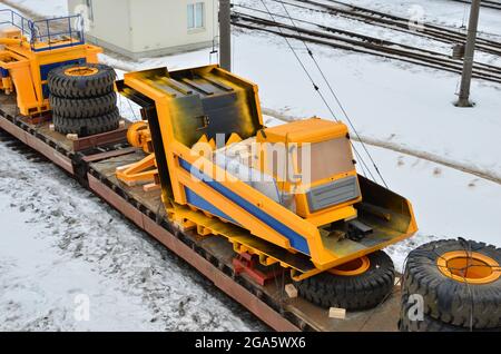 Chariot d'exploitation minière jaune démonté en pièces, cabine, corps, moteur électrique, entraînement, roues, chargées sur une plate-forme de chemin de fer. Logistique de livraison de Banque D'Images