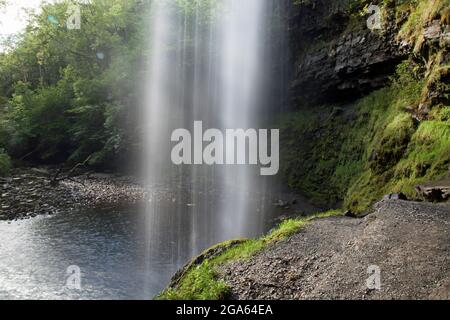 Photographie en exposition lente prise en regardant derrière les cascades de Henrhyd, Neath, la plus haute cascade du sud du pays de Galles à 90 pieds. Banque D'Images