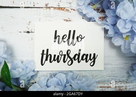 Carte Hello Thursday avec fleur en fleurs sur fond en bois Banque D'Images