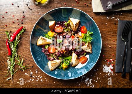 Salade de foie de poulet chaude avec sauce au Porto au miel et au vin. Crème de carottes, bacon, tomates cerises, brioche. Délicieux plats traditionnels sains servis en gros plan Banque D'Images