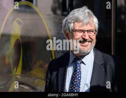 29 juillet 2021, Brandebourg, Schwedt/OT Criewen: Axel Vogel (Bündnis 90/Die Grünen), ministre de l'Agriculture, de l'Environnement et de la protection du climat de Brandebourg, se tient devant un oiseau imprimé sur le mur latéral lors de la présentation des deux premiers bus européens convertis en technologie de pile à hydrogène. Les véhicules à climat neutre sont en service avec l'Uckermärkische Verkehrsgesellschaft (UVG) et se déplacent également le long du parc national de la vallée de l'Oder inférieur. Les bus à hydrogène, autrefois diesel, utilisent maintenant de l'hydrogène vert produit par la société Enertrag en utilisant l'énergie éolienne de l'Uckermark RE Banque D'Images