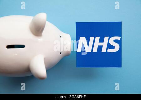 LONDRES, Royaume-Uni - juillet 2021 : logo du NHS National Health Service avec une banque de cochon d'épargne Banque D'Images