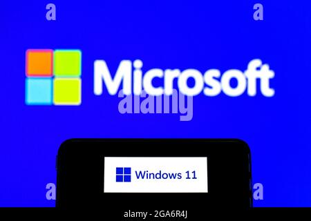 Dans cette illustration, un logo Windows 11 apparaît sur un smartphone avec un logo Microsoft Corporation en arrière-plan. Banque D'Images