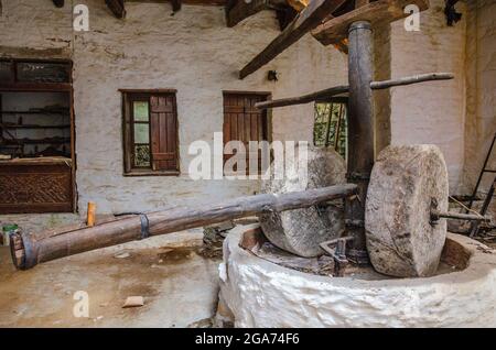 Machines anciennes de production d'huile d'olive, moulin à pierre et presse mécanique, moulin à huile pour olives. Abandon de la vieille pierre de meulage à Mani, Laconia, Grèce Banque D'Images