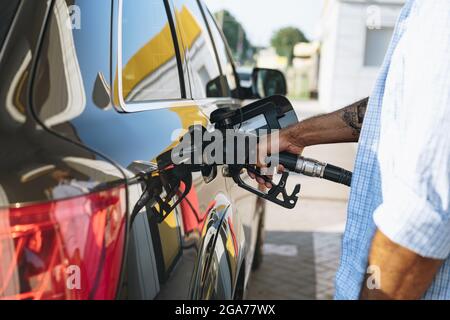 Homme remplissant de carburant dans la voiture à la station-service Banque D'Images