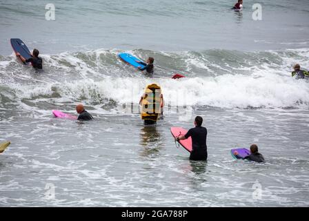 Trevaunance Cove,Cornwall,29 juillet 2021,UN grand nombre de surfeurs ont profité des vagues de Trevaunance Cove devant Storm Evert à St Agnes, Cornwall. La quatrième tempête d'été nommée est due à apporter des vents forts et de fortes pluies insaisonnières de nuit. Pendant que les surfeurs étaient dans l'eau les vacanciers aussi assis sur les grands rochers au sommet de la plage comme la marée est sorti.Credit: Keith Larby/Alay Live News Banque D'Images