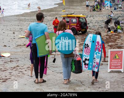 Trevaunance Cove,Cornwall,29 juillet 2021,UN grand nombre de surfeurs ont profité des vagues de Trevaunance Cove devant Storm Evert à St Agnes, Cornwall. La quatrième tempête d'été nommée est due à apporter des vents forts et de fortes pluies insaisonnières de nuit. Pendant que les surfeurs étaient dans l'eau les vacanciers aussi assis sur les grands rochers au sommet de la plage comme la marée est sorti.Credit: Keith Larby/Alay Live News Banque D'Images