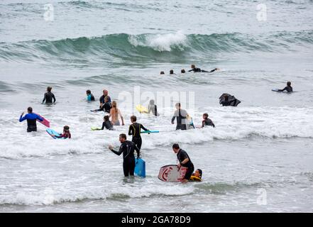 Trevaunance Cove,Cornwall,29 juillet 2021,UN grand nombre de surfeurs ont profité des vagues de Trevaunance Cove devant Storm Evert à St Agnes, Cornwall. La quatrième tempête d'été nommée est due à apporter des vents forts et de fortes pluies insaisonnières de nuit. Pendant que les surfeurs étaient dans l'eau les vacanciers aussi assis sur les grands rochers au sommet de la plage comme la marée est sorti.Credit: Keith Larby/Alay Live News Banque D'Images