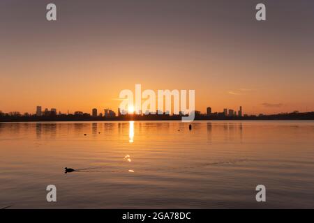 Coucher de soleil sur la ligne d'horizon de Rotterdam, vue depuis Kralingse Plas (lac de Kralingen) avec un ciel coloré se reflétant dans les eaux calmes du lac Banque D'Images