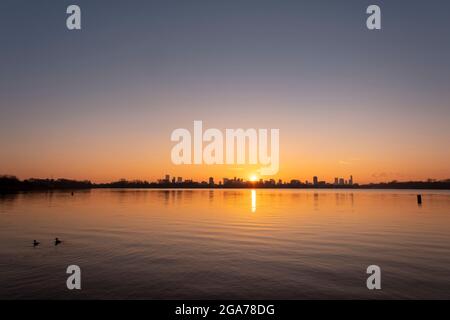 Coucher de soleil sur la ligne d'horizon de Rotterdam, vue depuis Kralingse Plas (lac de Kralingen) avec un ciel coloré se reflétant dans les eaux calmes du lac Banque D'Images