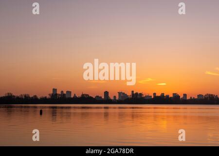 Coucher de soleil sur la ligne d'horizon de Rotterdam, vue depuis Kralingse Plas (lac de Kralingen) avec un ciel coloré se reflétant dans les eaux calmes du lac Banque D'Images