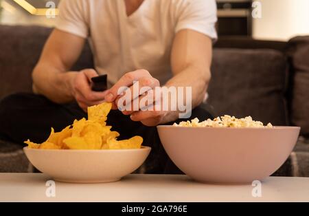 Gros plan de la main de l'homme, prenez les frites du bol Banque D'Images