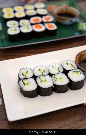 Une table avec deux assiettes de sushis végétariens, vue latérale, verticale Banque D'Images