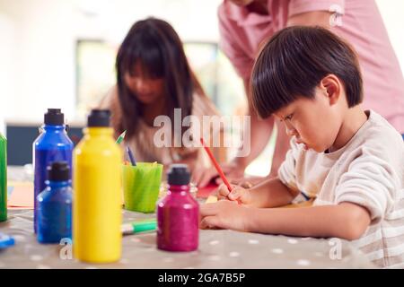 Père asiatique avec enfants s'amuser avec les enfants faire l'artisanat sur la table à la maison Banque D'Images