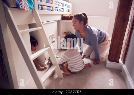Mère asiatique avec enfants s'amuser jouer avec des jouets dans la chambre à coucher ensemble Banque D'Images
