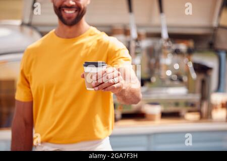 Gros plan sur Man Running Mobile Coffee Shop tenant la tasse Takeaway à l'extérieur à côté de Van Banque D'Images