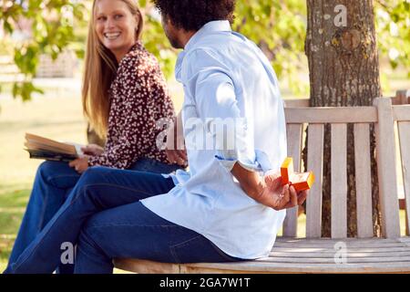 Mature Man sur le point de proposer à la femme dans Park Hiding Ring Box derrière le dos Banque D'Images