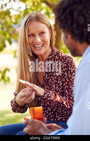 Romantique mature Man proposant à la femme surprise assis sur le banc de parc avec l'anneau d'engagement dans la boîte Banque D'Images