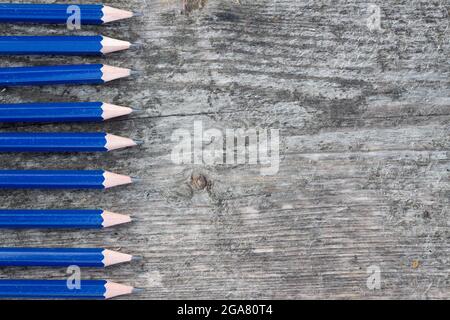 Bordure de crayons bleus sur fond de bois rustiques et abîmé avec espace de copie Banque D'Images