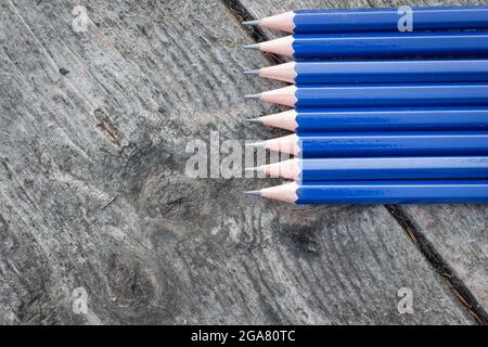 Bordure de crayons bleus sur fond de bois rustiques et abîmé avec espace de copie Banque D'Images