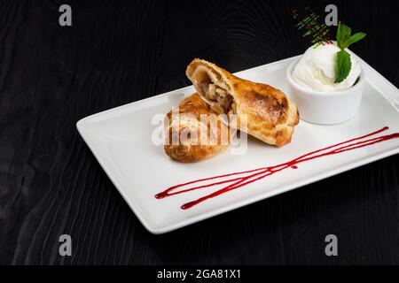 Strudel aux pommes, glace vanille et caramel décoré avec sauce baies Banque D'Images