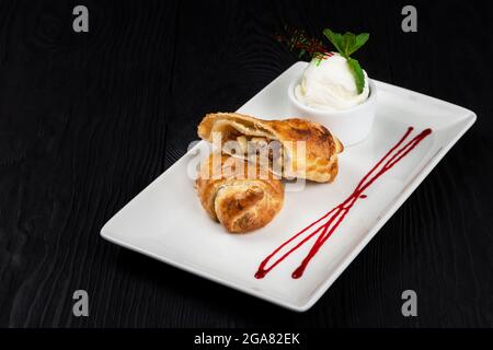 Strudel aux pommes, glace vanille et caramel décoré avec sauce baies Banque D'Images