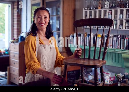 Portrait d'une femme asiatique mûre en train de restaurer des meubles en atelier à la maison Banque D'Images