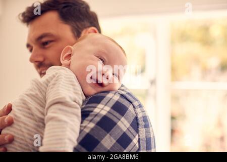 Le Père aimant câlin bébé fils se reposant sur l'épaule à la maison ensemble Banque D'Images