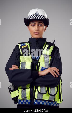 Portrait de studio de jeune femme grave officier de police contre fond clair Banque D'Images