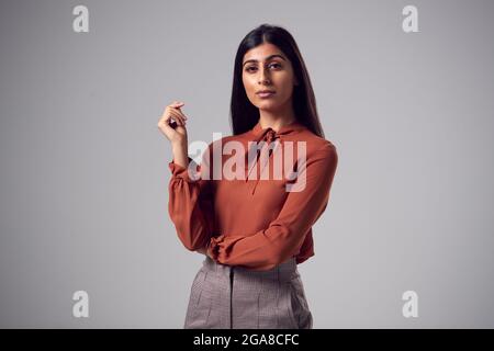 Studio Portrait de la jeune femme d'affaires sérieuse contre fond Uni Banque D'Images